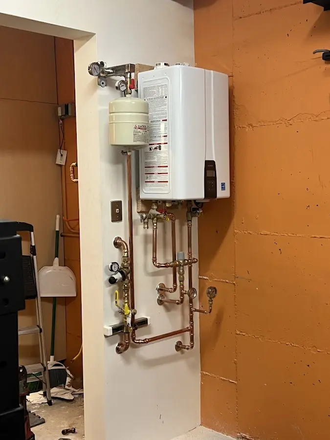 Plumbing technician inspecting water heater connections in Atoka
